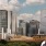 Man viewing the downtown skyline with tall, modern skyscrapers under a partly cloudy sky