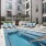 Outdoor pool area at an apartment complex with lounge chairs and modern design